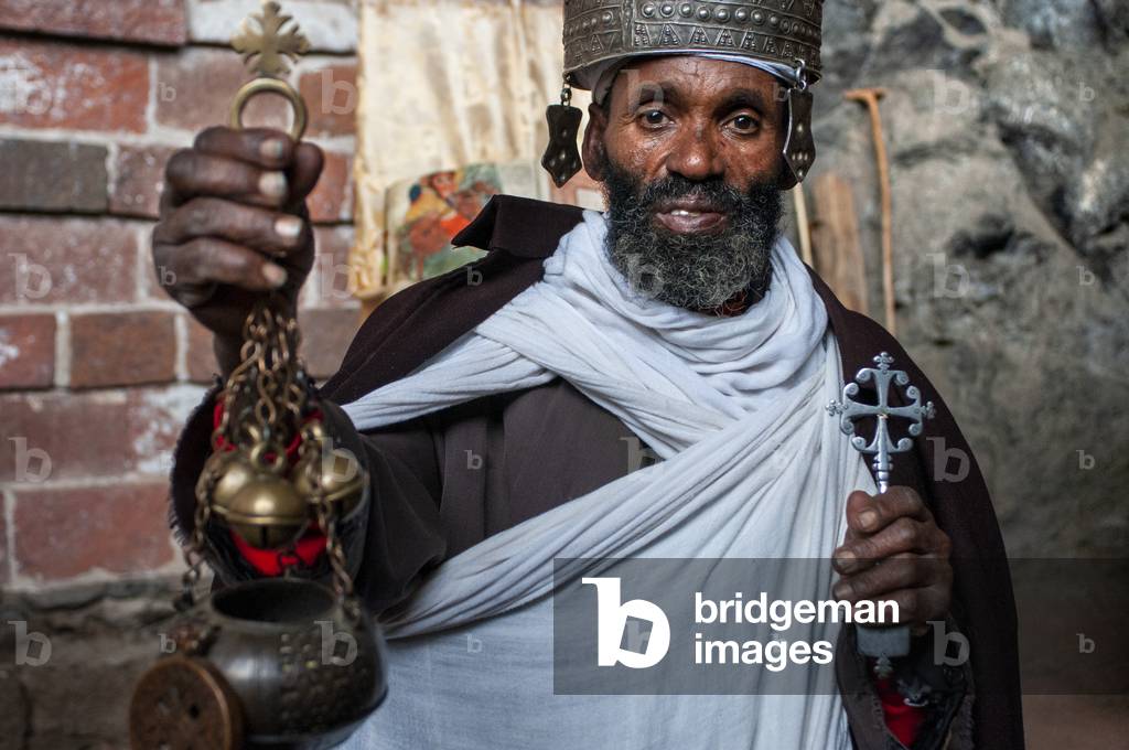 Portrait of an ethiopian orthodox priest holding a cross in nakuto lab cave church, Amhara region, Lalibela, Ethiopia (photo)