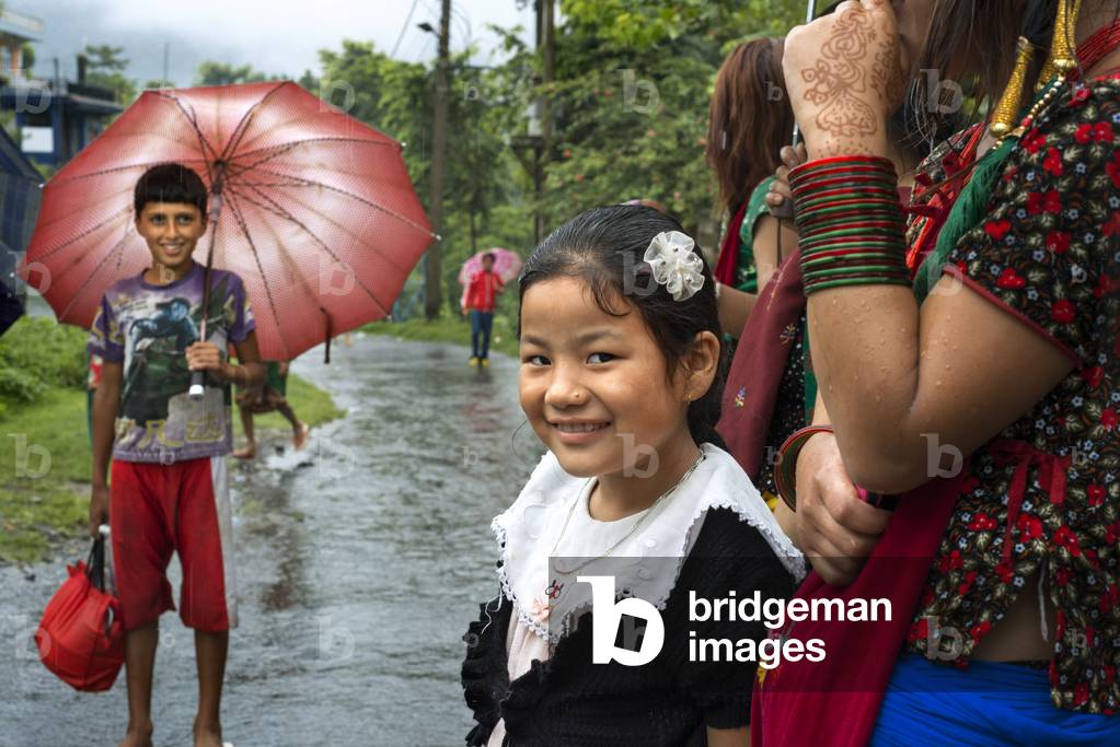 Portrait of group of young Nepalese people with umbrella near Bandipur Hanging bridge in Nepal, Kathmandu Valley (photo)