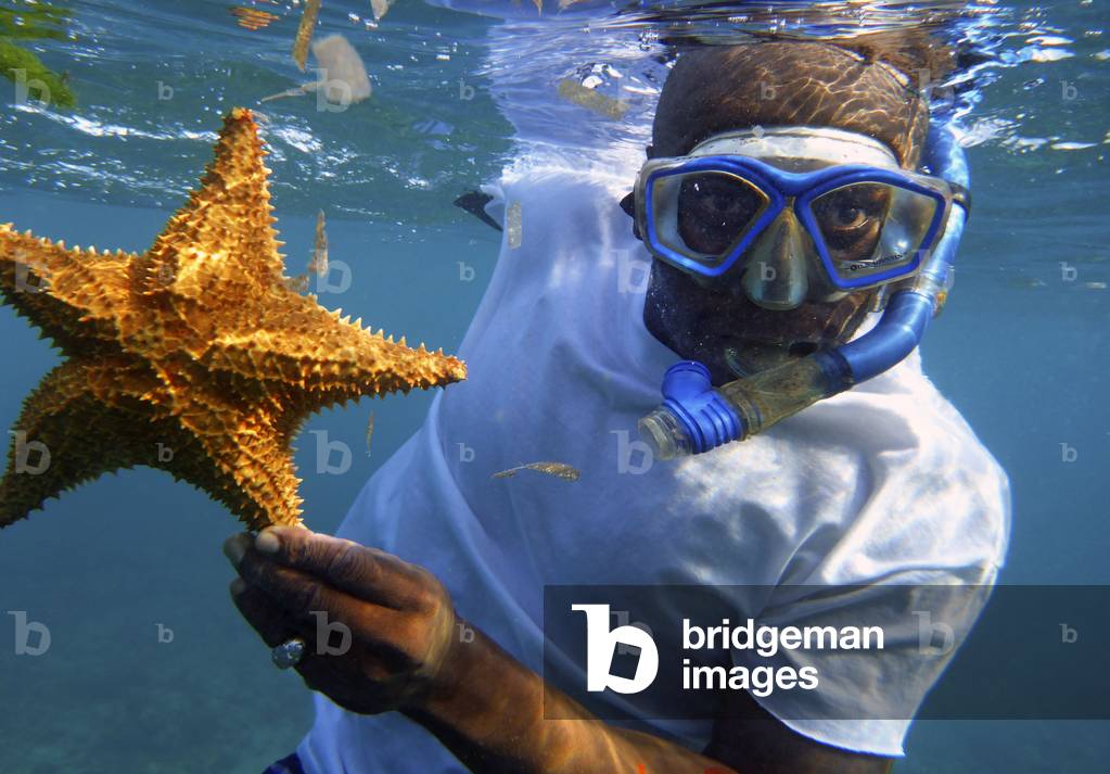 Local man with a starfish, Snorkeling in the beach, Corn Island, Caribbean Sea, Nicaragua, Central America, America (photo)