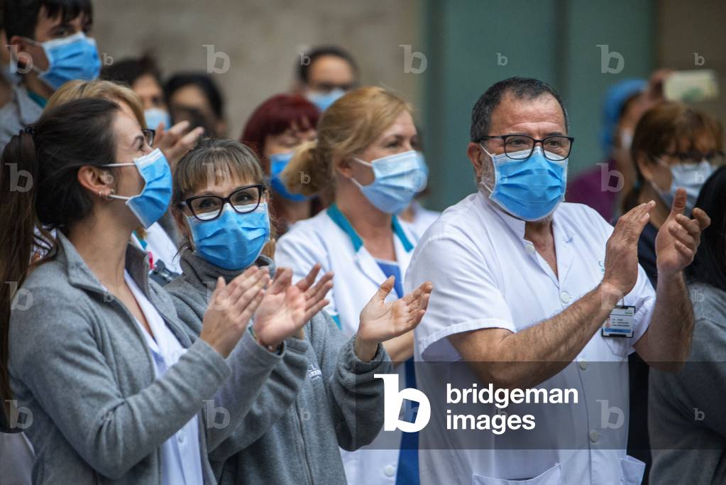 A group of doctors and health personnel from the Hospital clinic applauding those that show gratitude towards them during the coronavirus crisis, Barcelona, Spain, 9th April 2020 (photo)