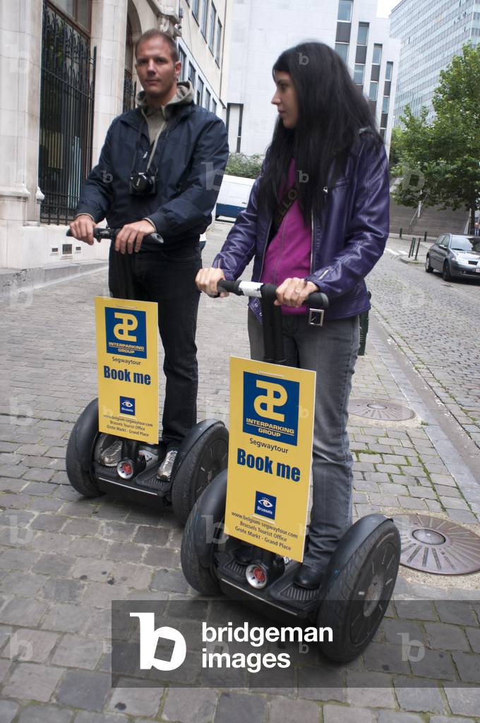 A tourist couple with a rent segway across the street in Brussels, Begium (photo)