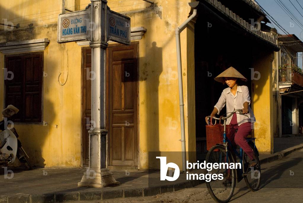 Woman on a bike, Vietnam, Quang Nam Province, Hoi An, Old Town, Bach Dang street, Vietnam (photo)