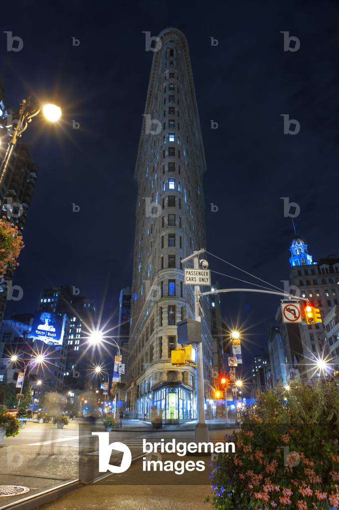 The Flatiron building at night. One of the first skyscrapers of New York City, it is located in the Flatiron District in Manhattan, USA (photo)