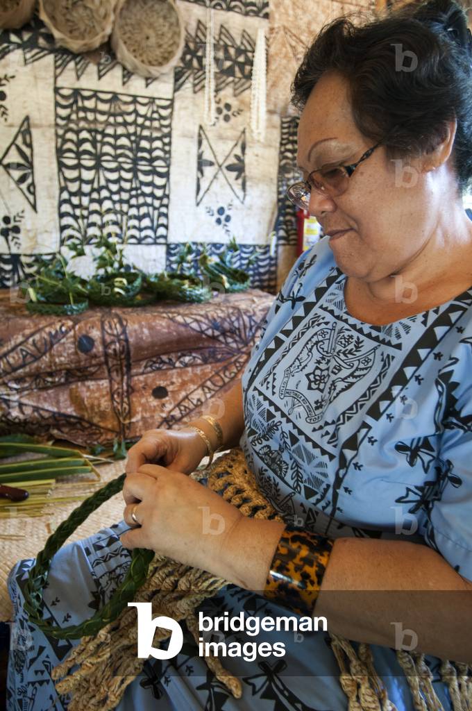 Old woman doing crafts in Polynesian Cultural Center, O'ahu, Hawaii (photo)
