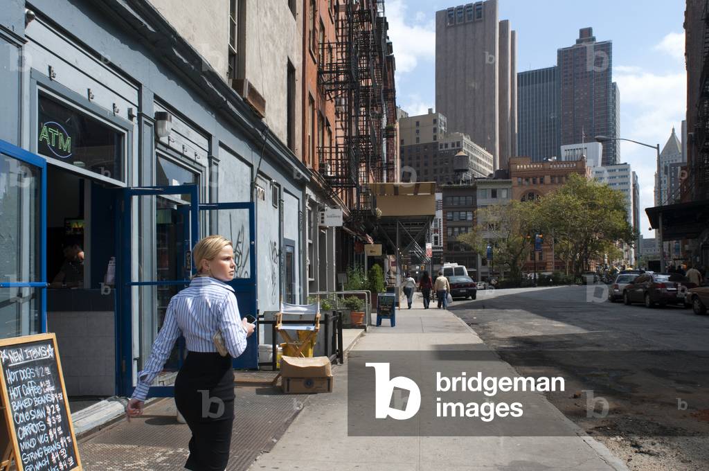 A worker woman walks through the streets of Soho, Manhattan, New York, USA (photo)