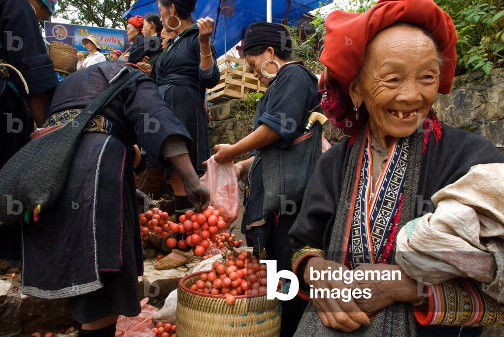 Women from Red dao Hmong ethnic group selling fresh vegetables and fruits at Bac Ha market, Sapa region, Lao Cai Province, Vietnam (photo)