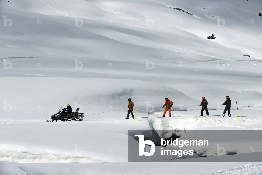 Line of people skiing with snowmobile, Baqueira Beret, Ski resort, Pyrenees, Aran Valley, Lleida, Catalonia, Spain (photo)