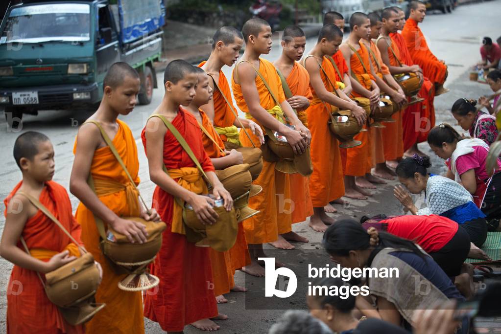 Tak bat ritual - Buddhist monks receive rice and food from pupulation in early morning in Luang Prabang, Laos, Asia (photo)