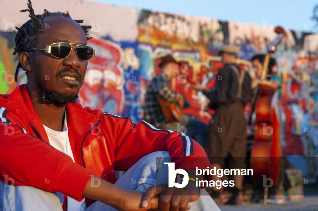 A former part of the Berlin Wall death strip, Black people man and Graffiti on Mauerpark wall in Berlin, Germany (photo)