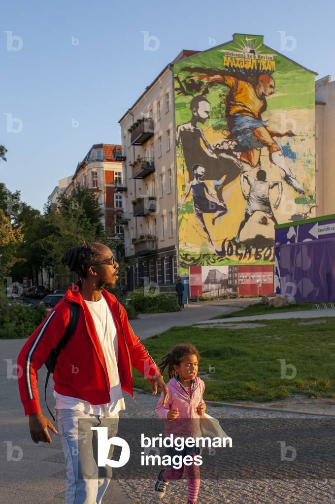 Black father with his daughter and a house near the Mauerpark, Berlin in evening light Germany, Wellcome to Belin, brazilian team, Joga bonito, Mauerpa (photo)
