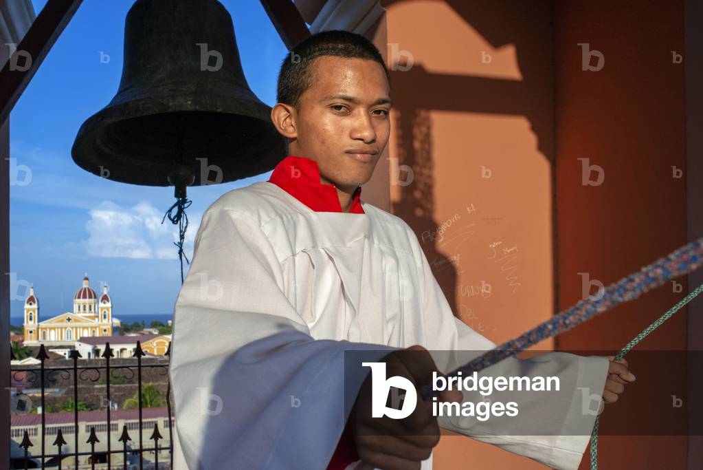 Back cathedral of Granada, Altar boy ringing the bells in the Iglesia la Merced of Granada Nicaragua, Central America, America (photo)