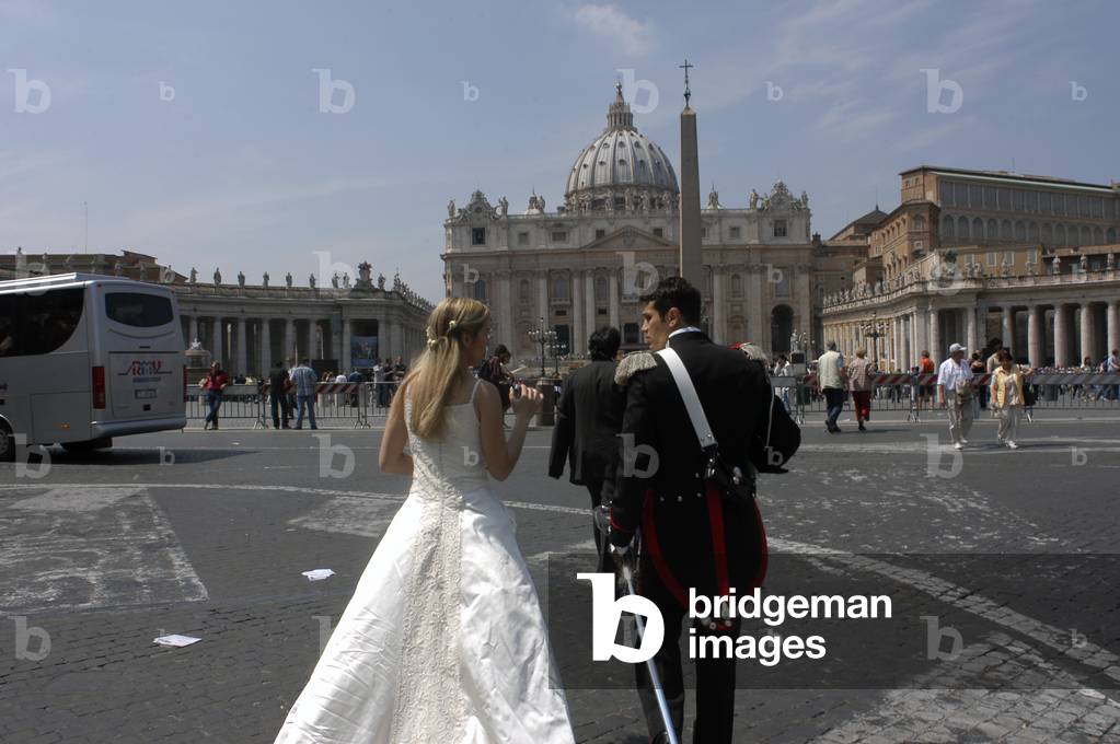 A bride and groom walk through St Peters Square in Vatican City, Italy (photo)