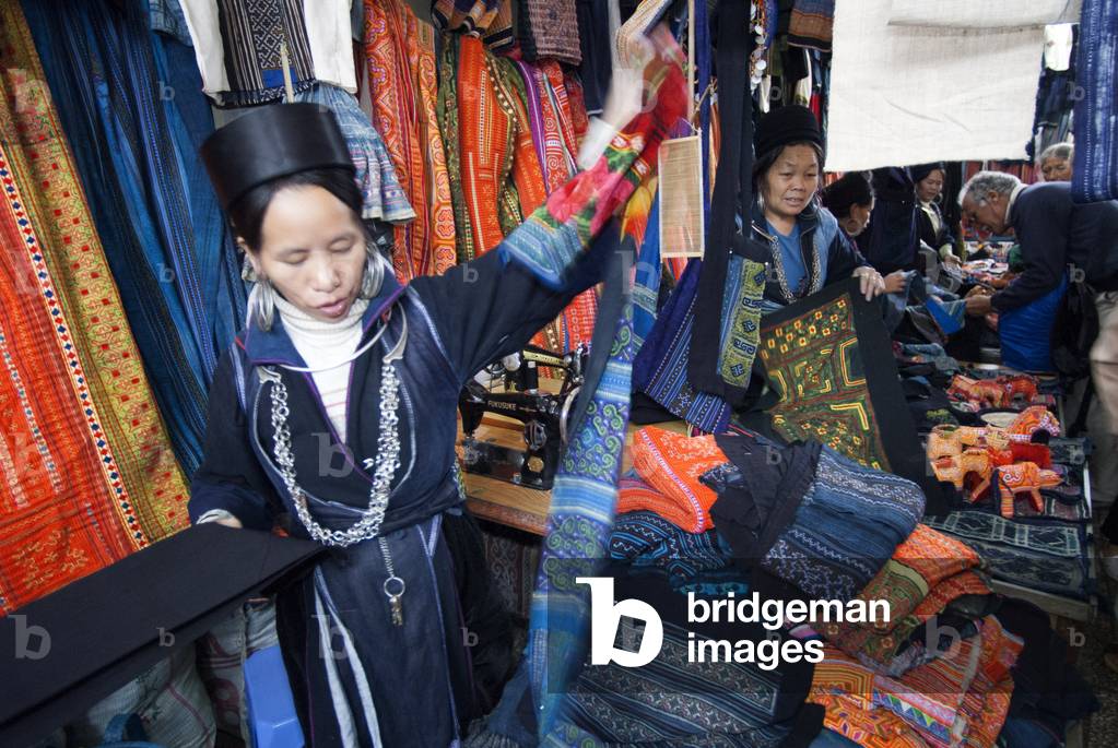 Black hmong women making and selling tribal handicrafts and clothes iniside the market in Sapa, Lao Cai Province, Vietnam (photo)