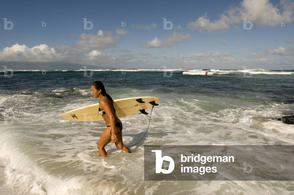 Surfer entering the water at Hookipa Beach, Maui, Hawaii (photo)