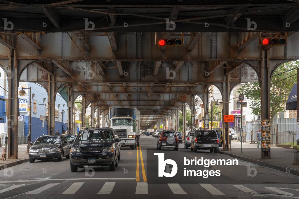 Cars driving on Nothtern bulevard Queens under metro railway (photo)