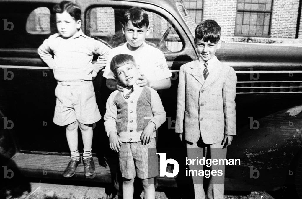 Four boys standing in front of a vintage car, Bronx, New York State, USA, 1930s