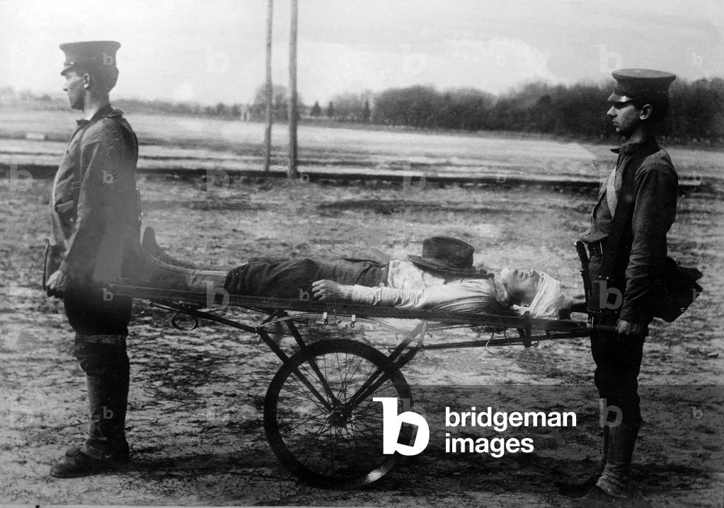 Injured soldier on a make-shift stretcher with wheels, c.1914-18 (b/w photo)