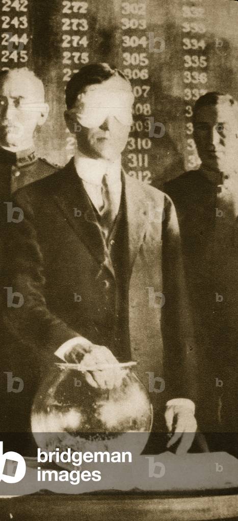 The American Secretary of War, Newton D. Baker, drawing the first number in the selective draft (sepia photo)