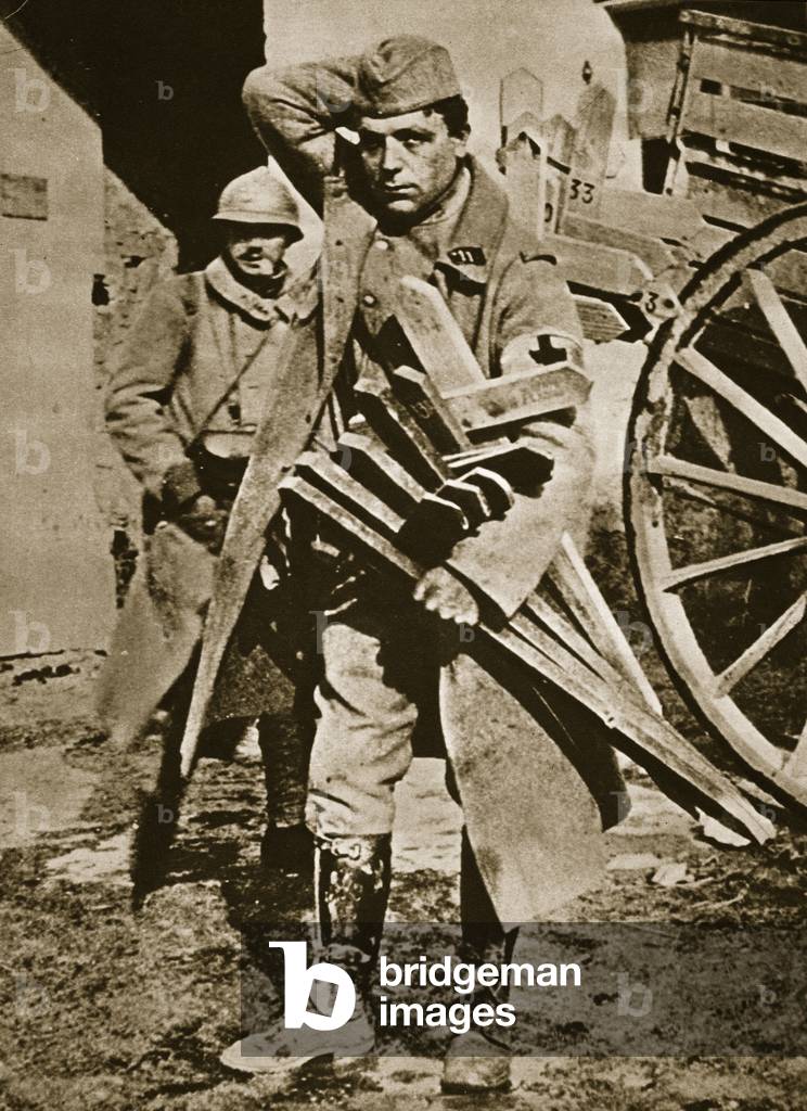 French soldier with wooden crosses to be placed on temporary graves (sepia photo)