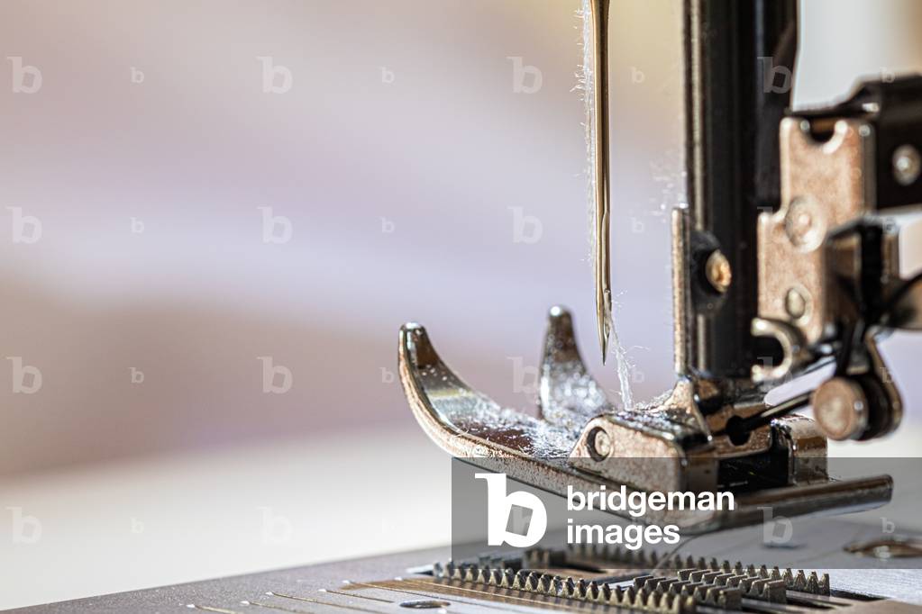 Sewing machine up close, on the foot and the needle, making smocks for caregivers, April 2020 (photo)