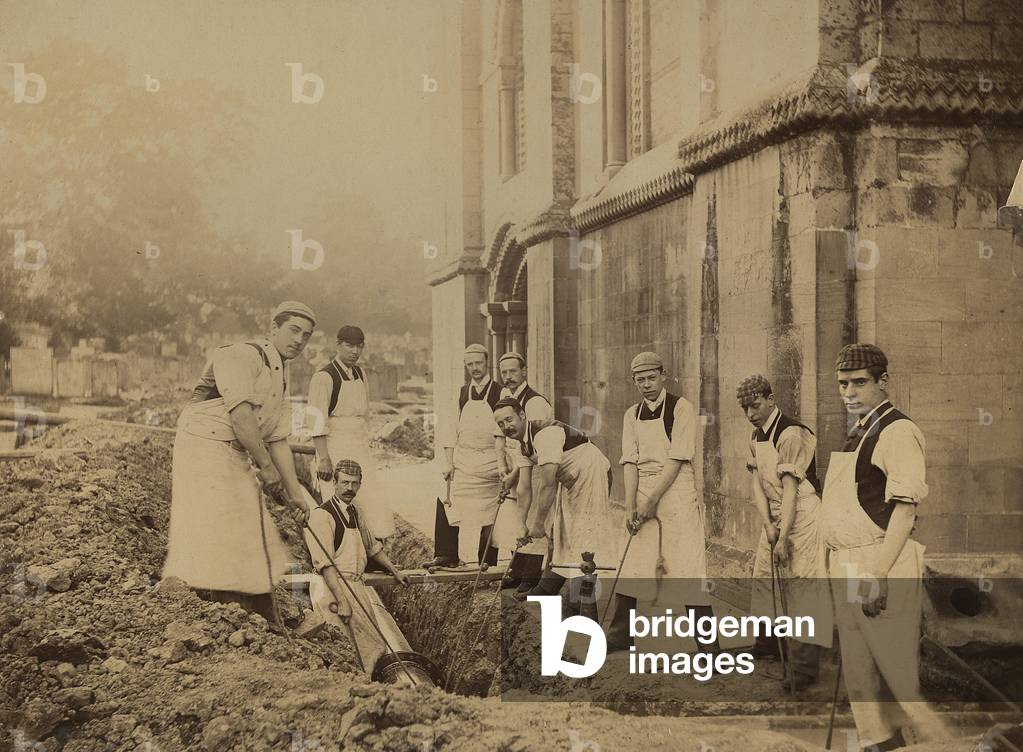 Men installing a gas pipe at Southwell Minster, Nottinghamshire, early 20th century (b/w photo)