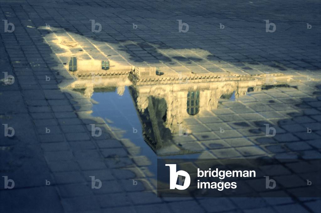 Detail of a pavillon of the Cour Napoleon, Le Louvre reflecting in a puddle (photo)