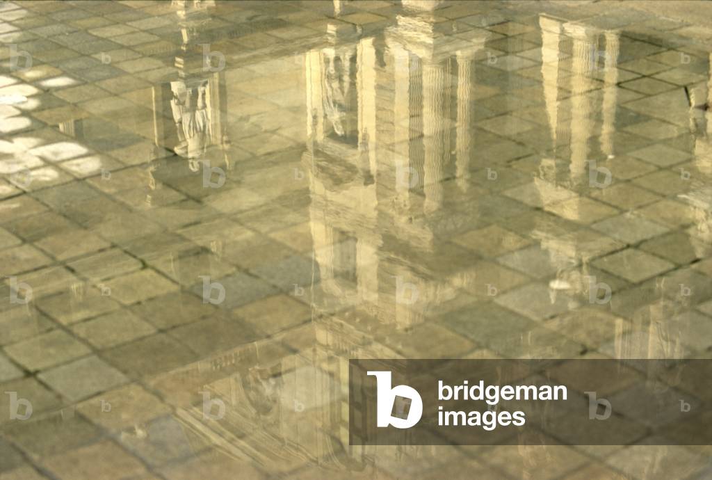 Detail of a pavillon of the Cour Napoleon, Le Louvre reflecting in a puddle (photo)