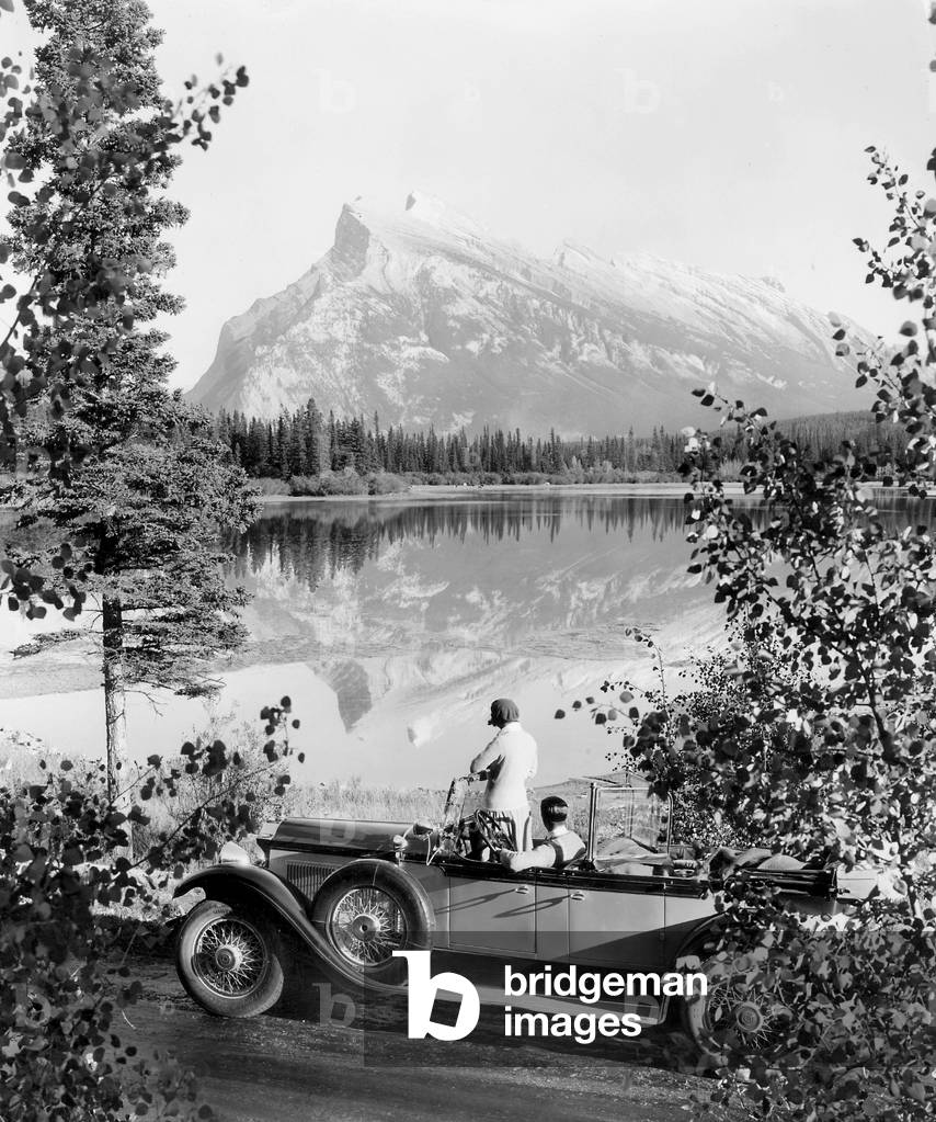 Car travelers on the shore of a lake, 1930 (b/w photo)