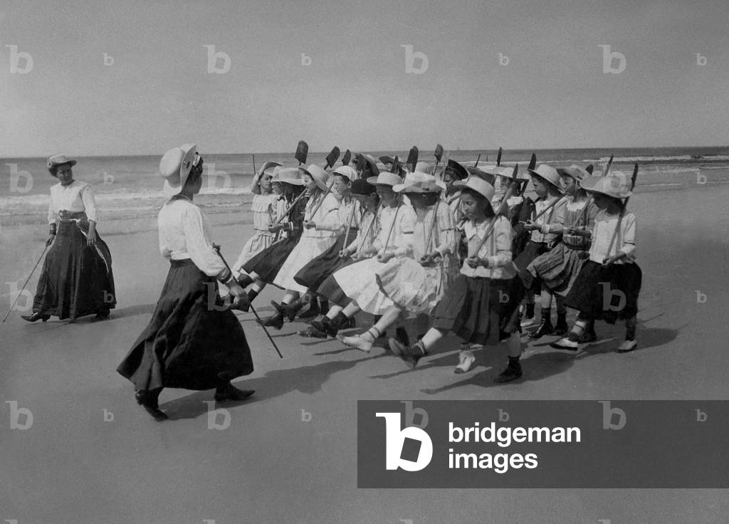 A group of girls marching along Borkum beach, 1913 (b/w photo)