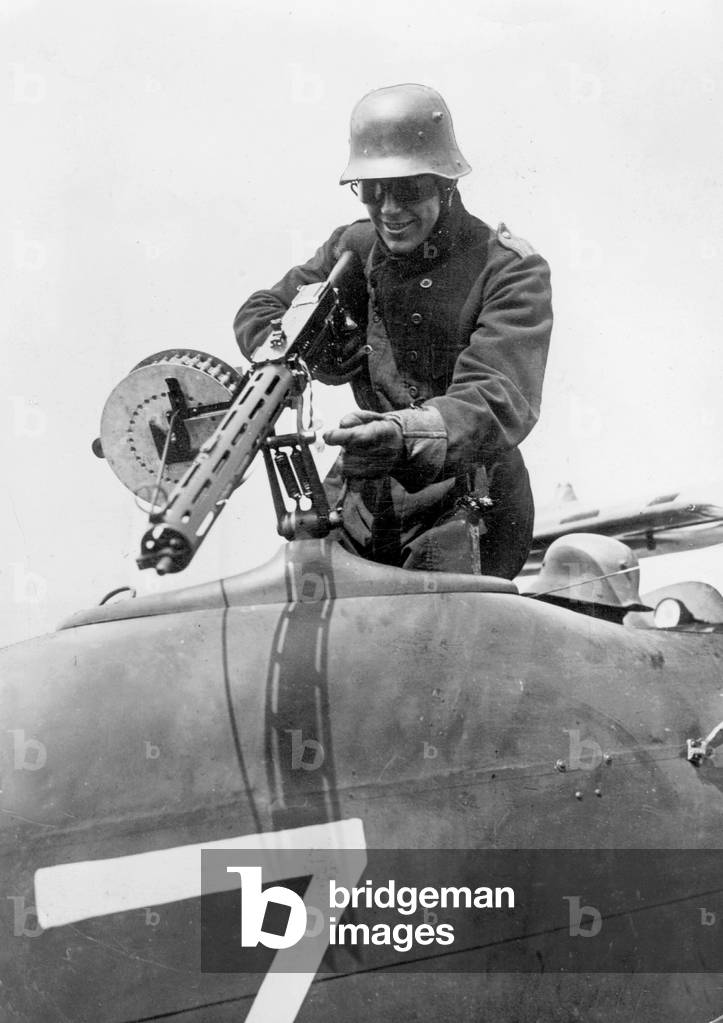 At a demonstration in front of journalists, a gunner carries a machine gun in an 'infantry flyer', on the airfield Doberitz in Berlin, 1918 (b/w photo)