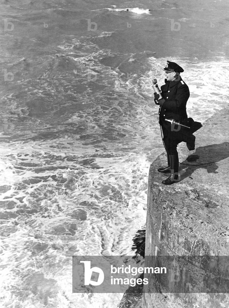 A journalist member of the propaganda company reports live from the roaring Atlantic Ocean (b/w photo)