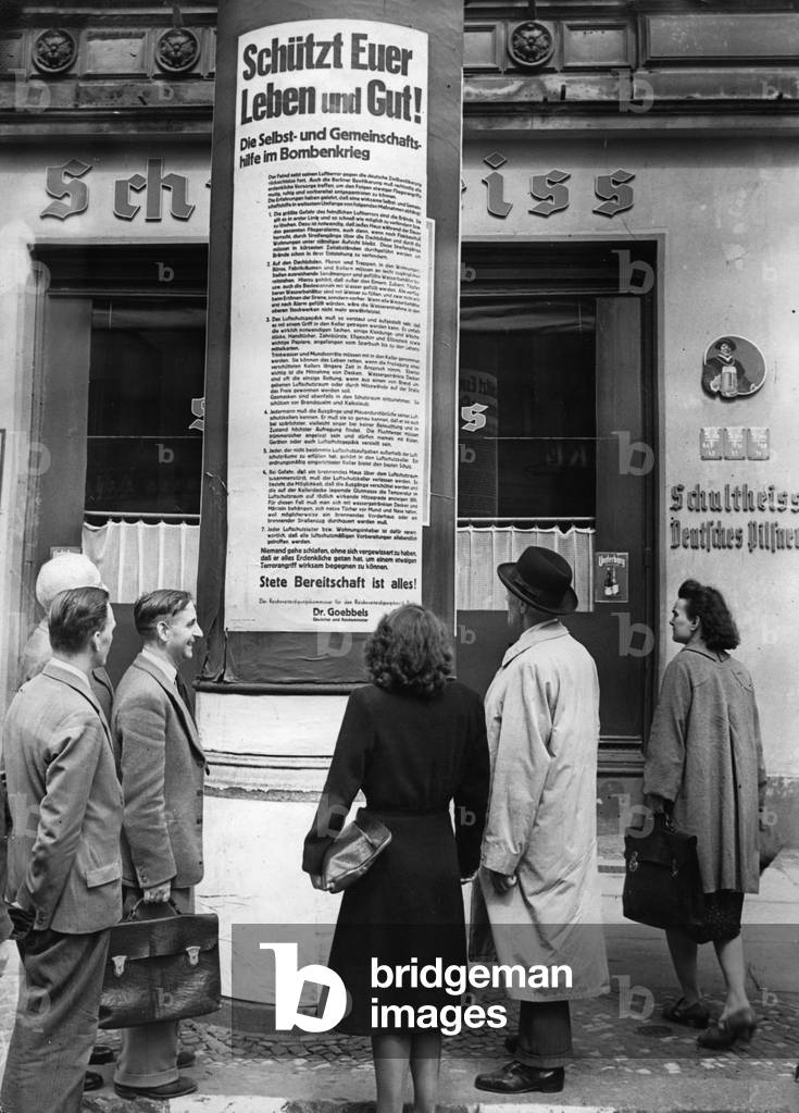 The population reads placards on the air raid in Berlin, 1943 (b/w photo)