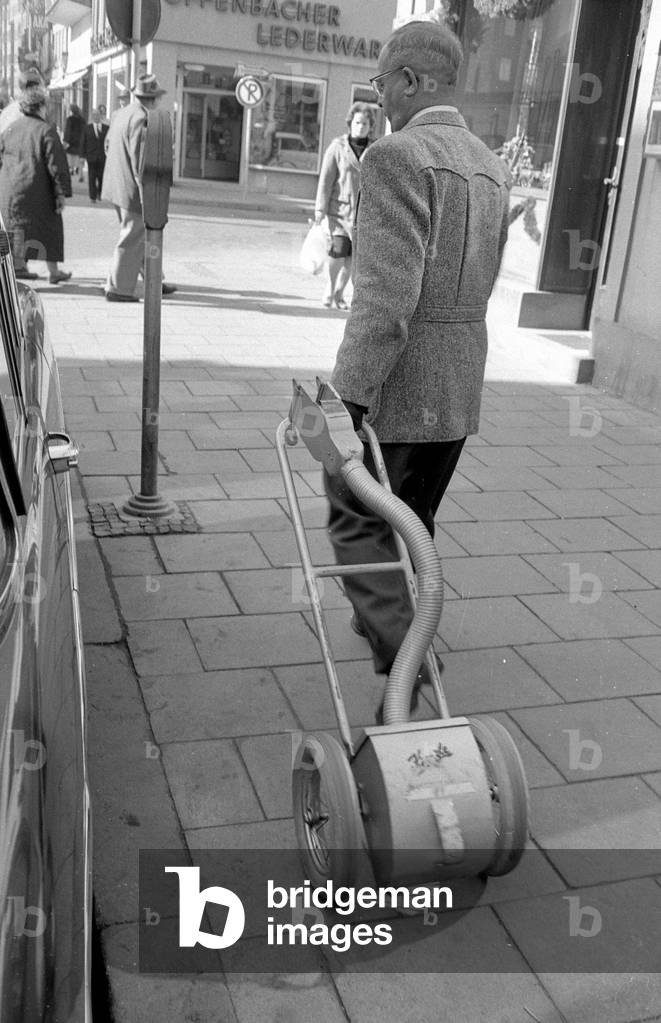 Parking meters are being emptied in the center of Munich, 1959 (b/w photo)