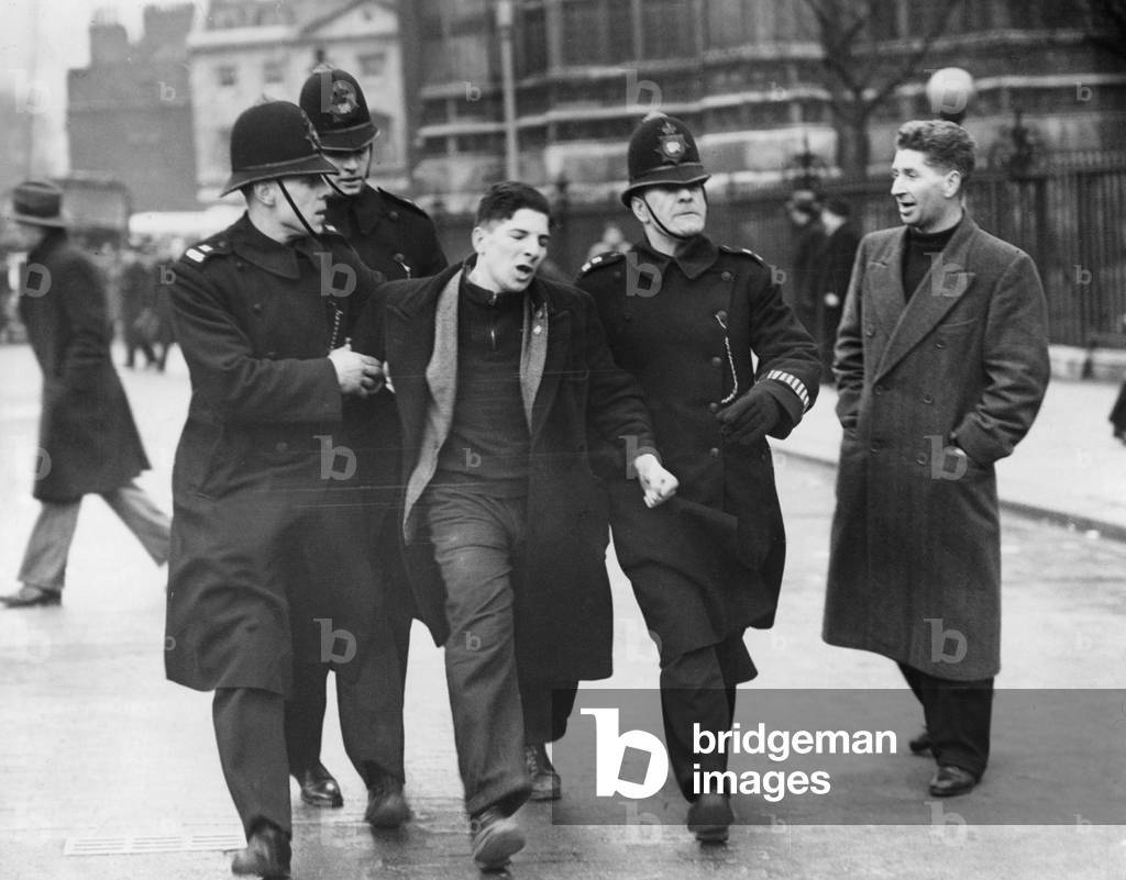 Policemen lead a demonstrator away in London, 1939 (b/w photo)