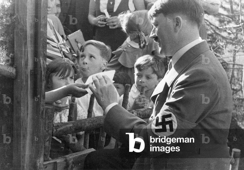 Adolf Hitler signs autographs, 1938 (b/w photo)