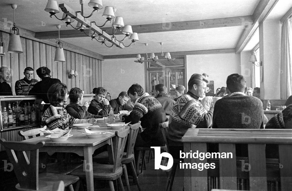 Austrian skiers while eating in Weissseehaus, 1962 (b/w photo)