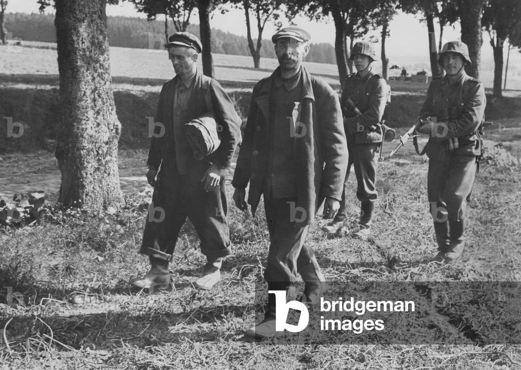 Soldiers of the Waffen SS force Polish civilians along (b/w photo)