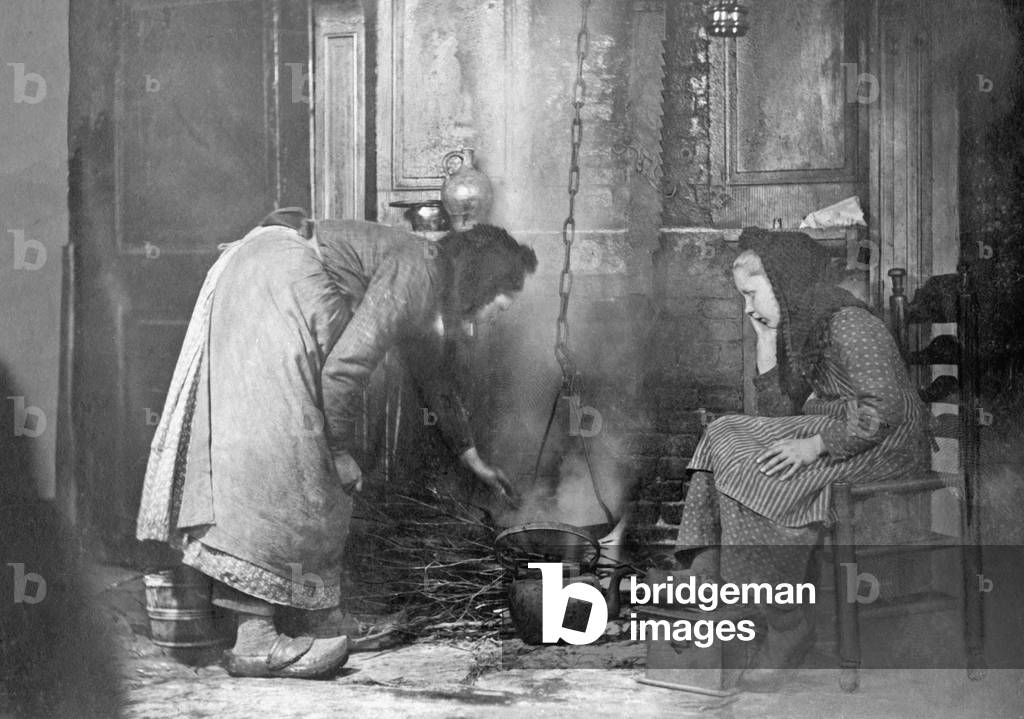 Peasant woman at the stove, c.1900 (b/w photo)