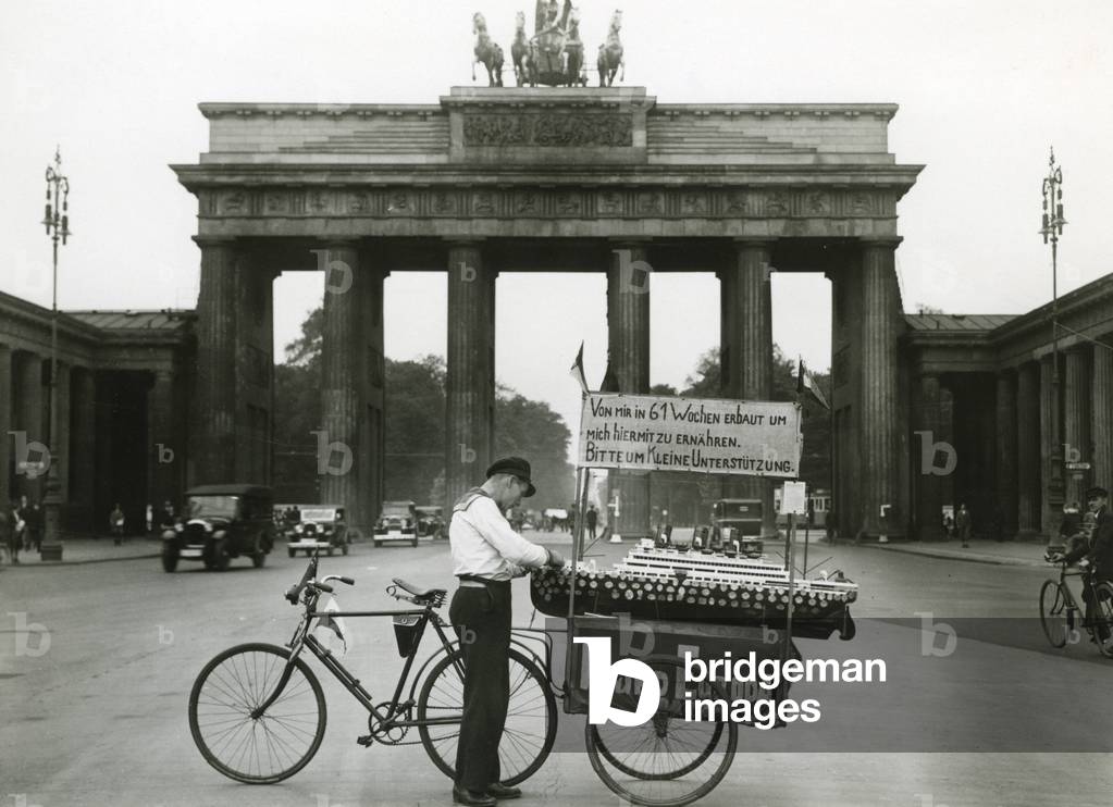 Unemployed sailor with his model ship in front of the Brandenburg Gate in Berlin, 1929-1932