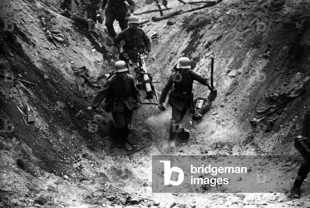German soldiers advance with a machine gun, 1918 (b/w photo)