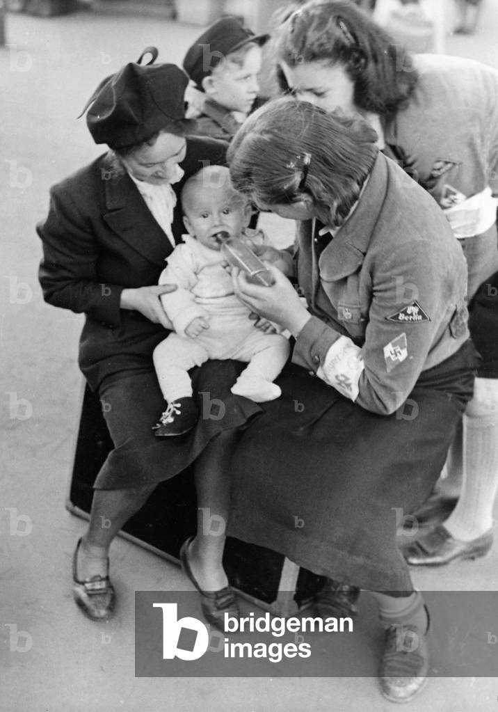 BDM girls look after a woman and her child at the Kinderlandverschickung, 1943 (b/w photo)