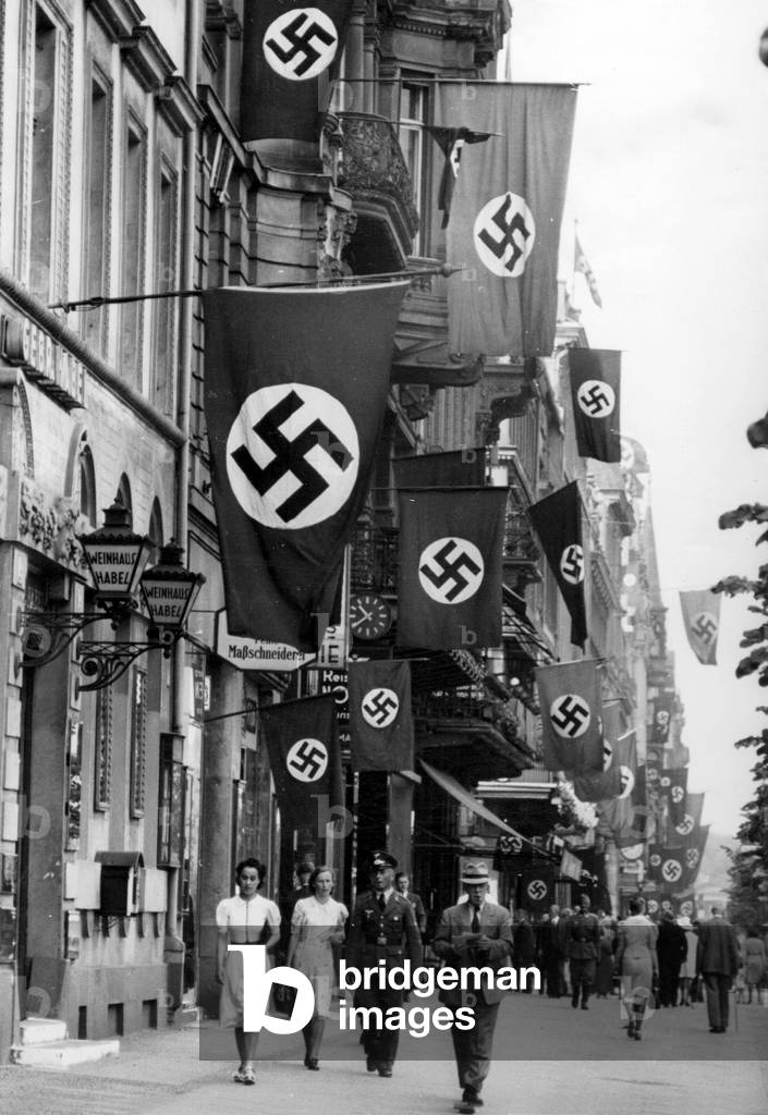Pedestrians in Berlin, which is decorated because of the victory of the French campaign, 1940 (b/w photo)