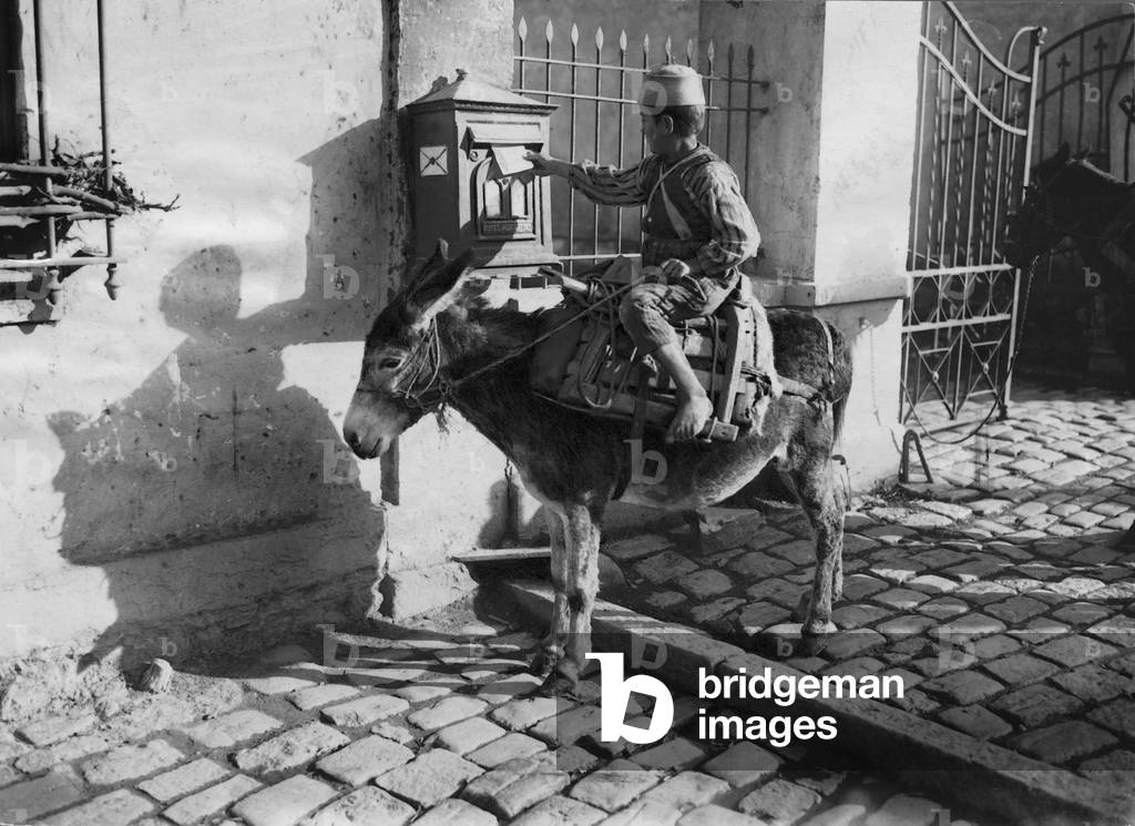 An African posts a letter in the mailbox, 1925 (b/w photo)