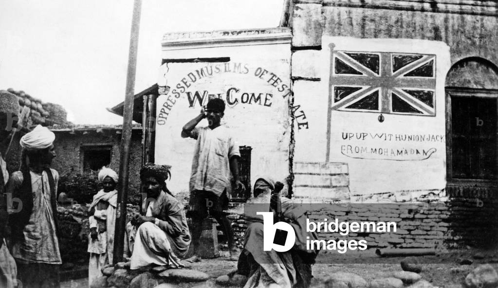 Posters on house walls in Kashmir in British India, 1931 (b/w photo)