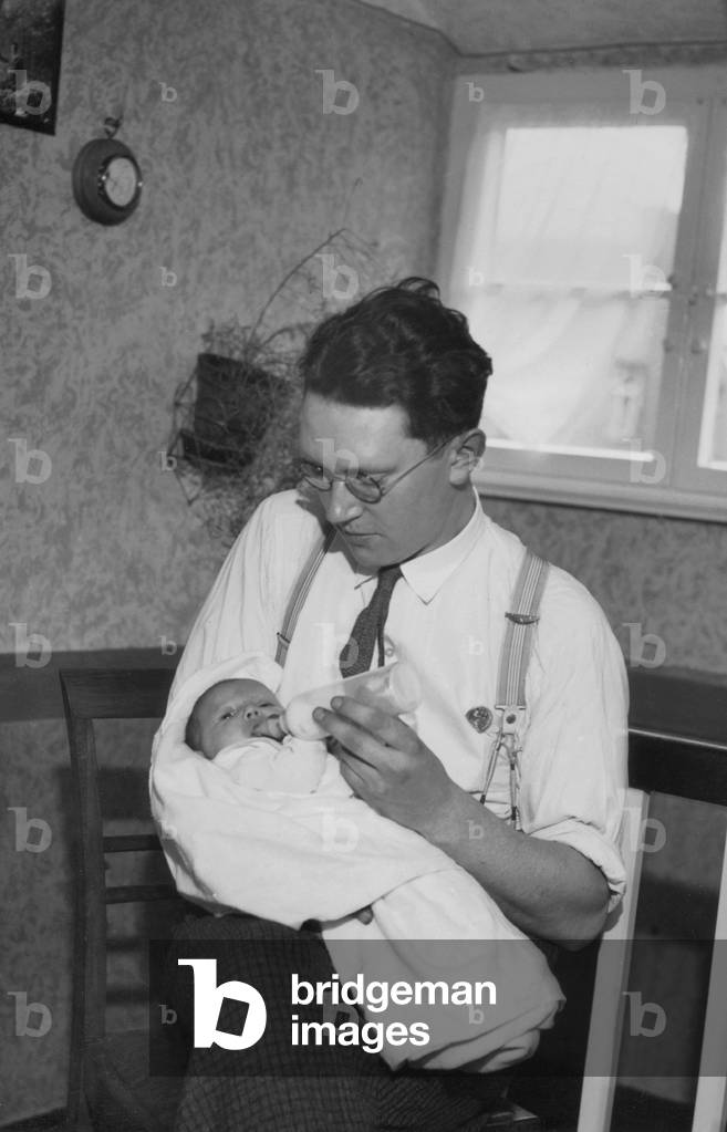 Young father and baby, 1934 (b/w photo)