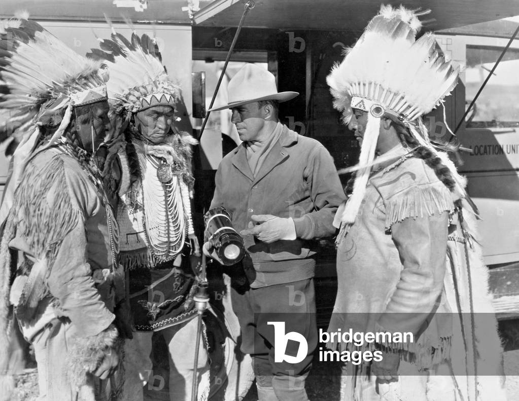 Raoul Walsh with Indians during filming, 1930 (b/w photo)