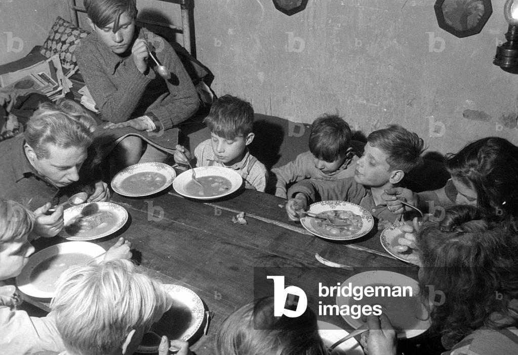Refugee family in their home near Muenster, 1954 (b/w photo)