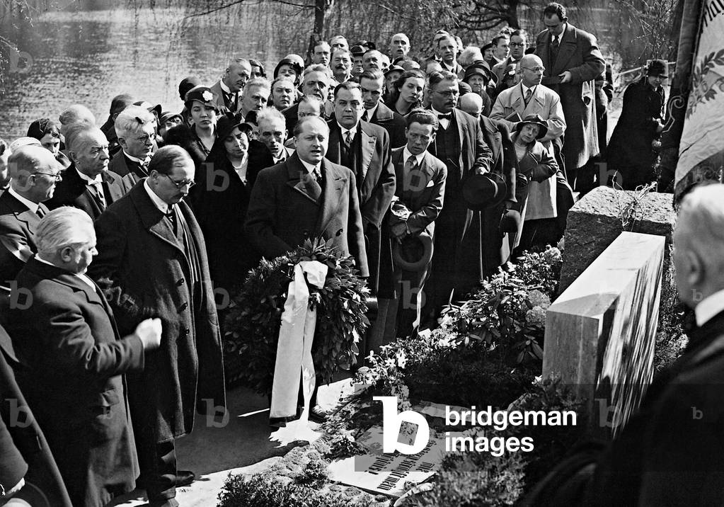Gottfried Benn at the memorial grave of Arno Holz (b/w photo)