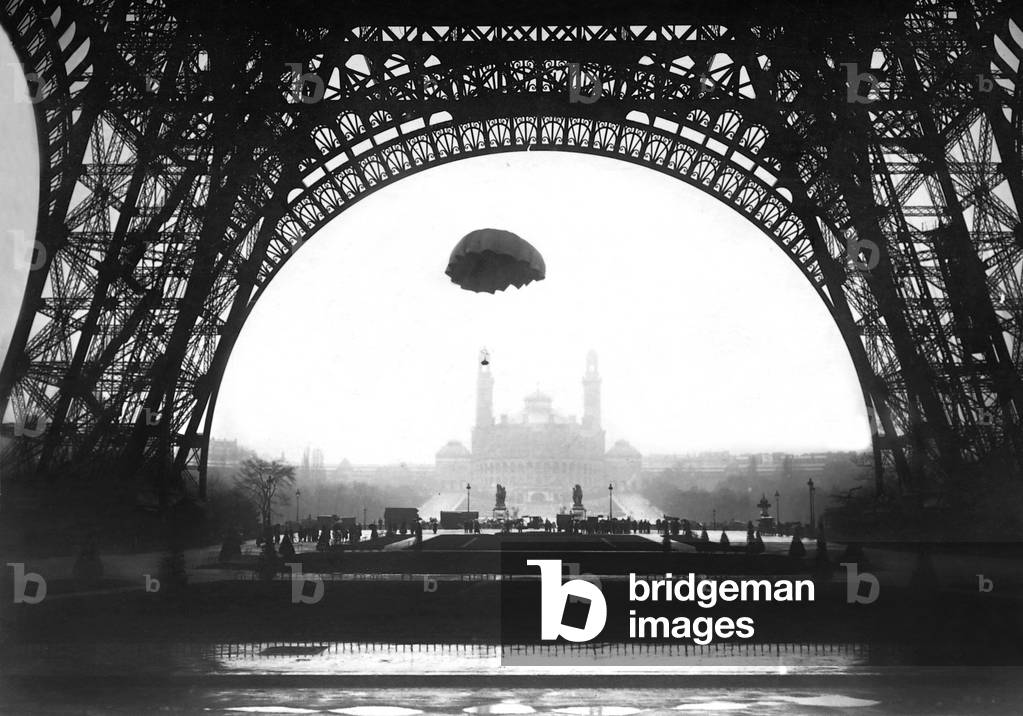 A parachute developed by the inventor Ors descends in front of the Eiffel Tower in Paris, 1913 (b/w photo)
