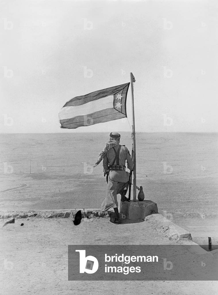 An Iraqi soldier watches the desert and guards his states' territory from a watchtower, Iraq, 1934 (b/w photo)